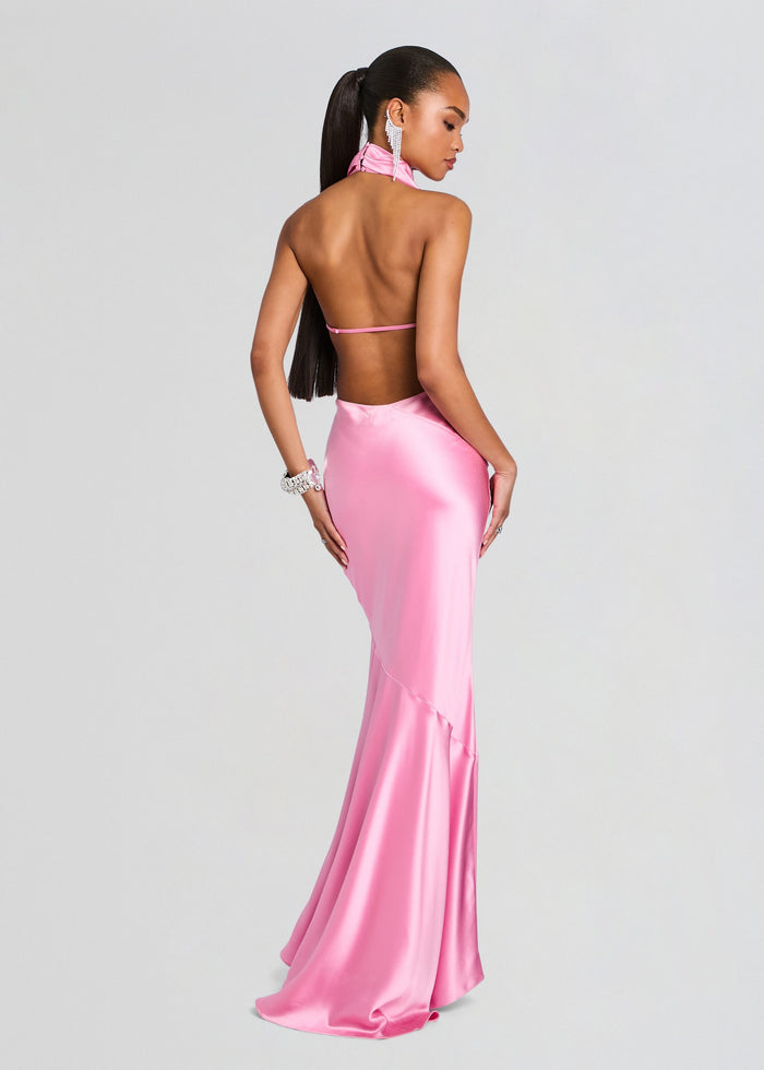 Back view of a model in a pink satin Luneth Dress with an open back and flowing mermaid skirt. media 4 of 5