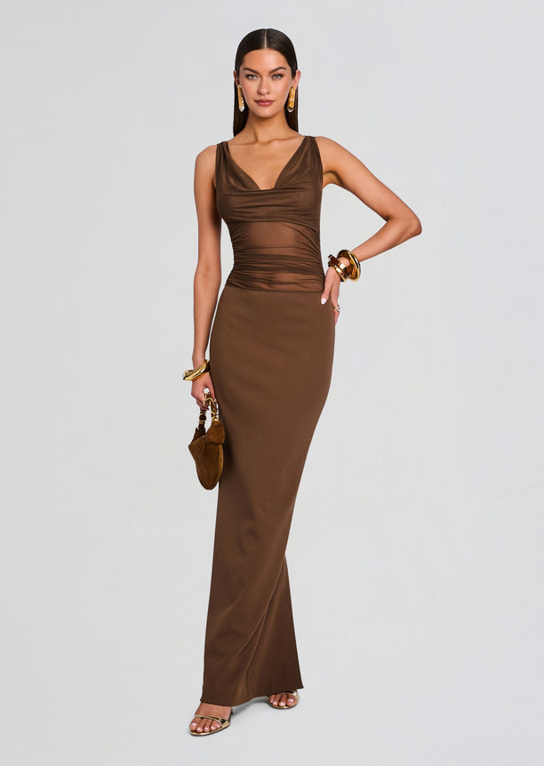 Model wearing Marla Maxi Dress in brown with ruched bust and floor length skirt, accessorized with gold jewelry.