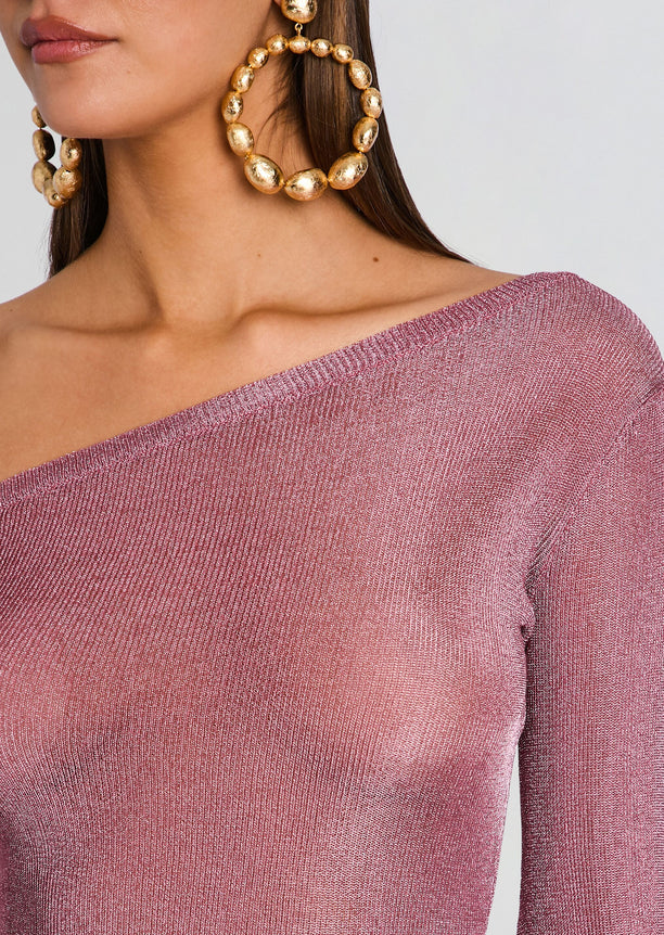 Close up of pink metallic knit fabric at the off shoulder neckline with oversized gold hoop earrings.
