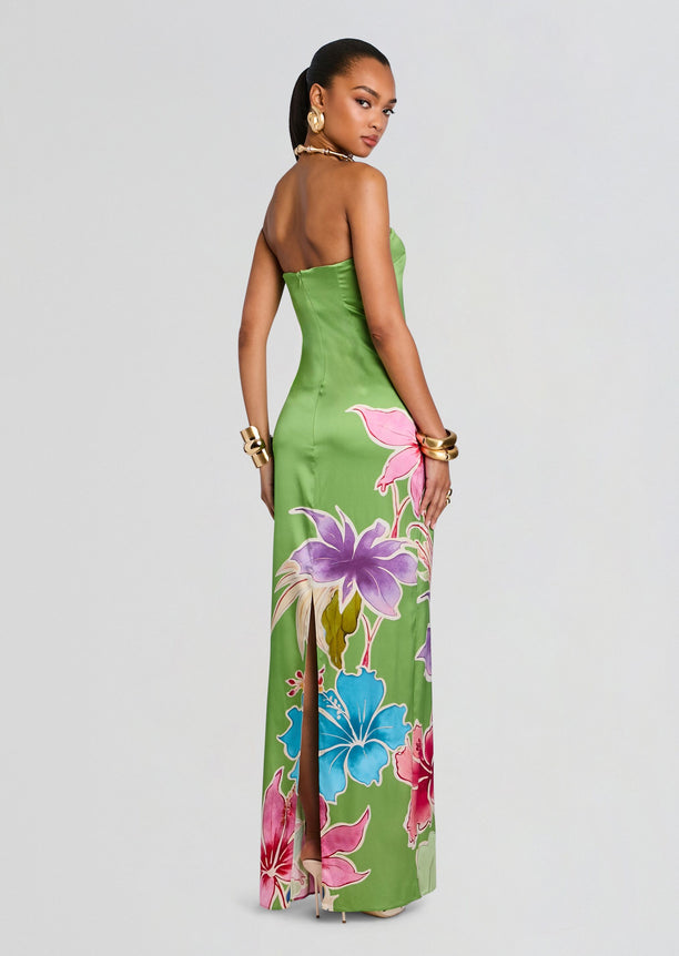 Back view of a green Vivi Silk Dress with bold tropical flowers in pink purple and blue along the skirt.