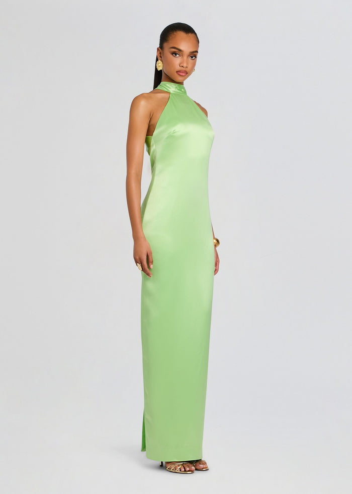 Side profile of a model in a lime green satin maxi dress with a small slit and metallic sandals media 3 of 5