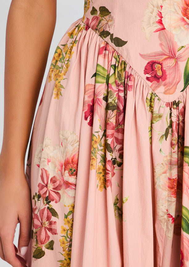 Close-up of pink floral dress fabric showing a gathered waist seam and pleats.
