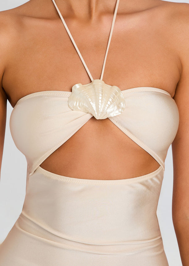 Close-up of beige bandeau top featuring a seashell knot and halter neck strap.