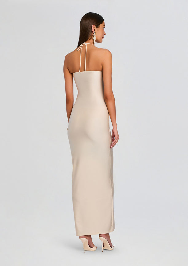 Back view of a cream halter neck maxi dress with thin straps tied at the back of the neck