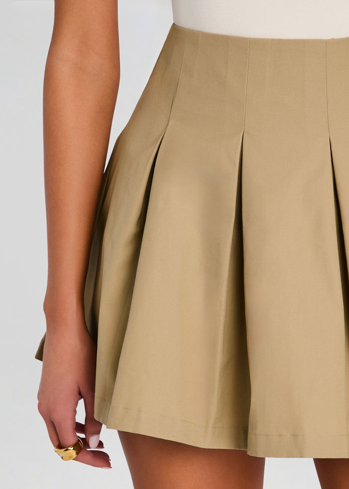 Close up of beige pleated mini skirt showing structured waistband and deep pleats media 3 of 5