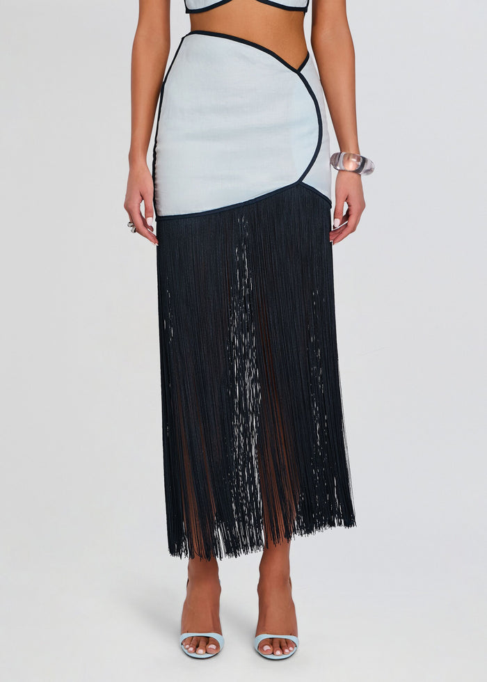 Close up of the Joelle Skirt waist showing pale blue fabric with navy piping and the starting point of the black fringe hem. media 1 of 5