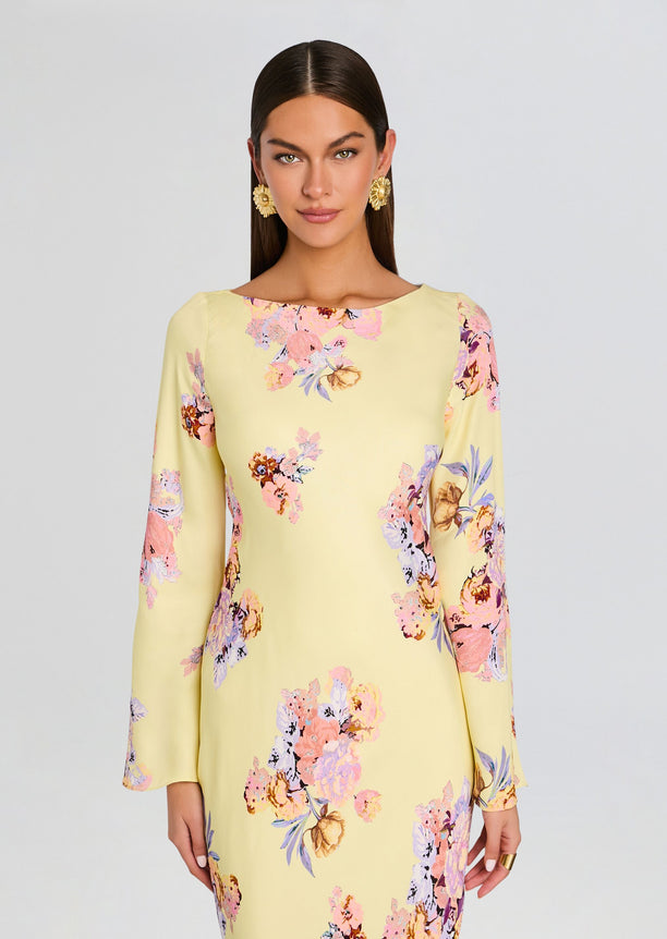 Front view of model wearing pale yellow floral Kysha Long Bias Dress with long sleeves.