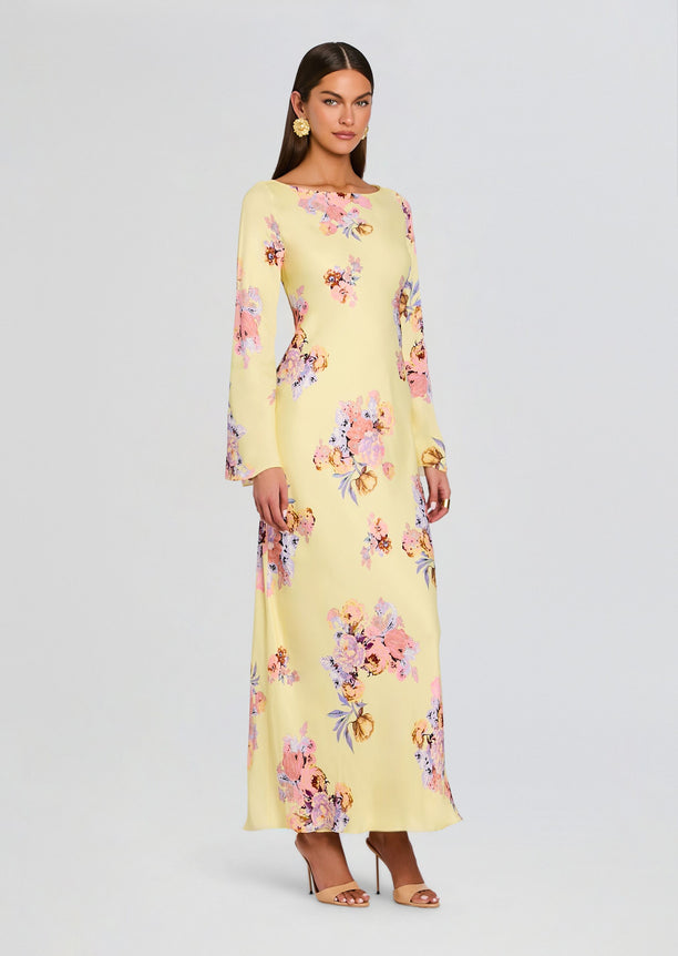 Model wearing a pale yellow floral Kysha Long Bias Dress with long sleeves and full-length silhouette.