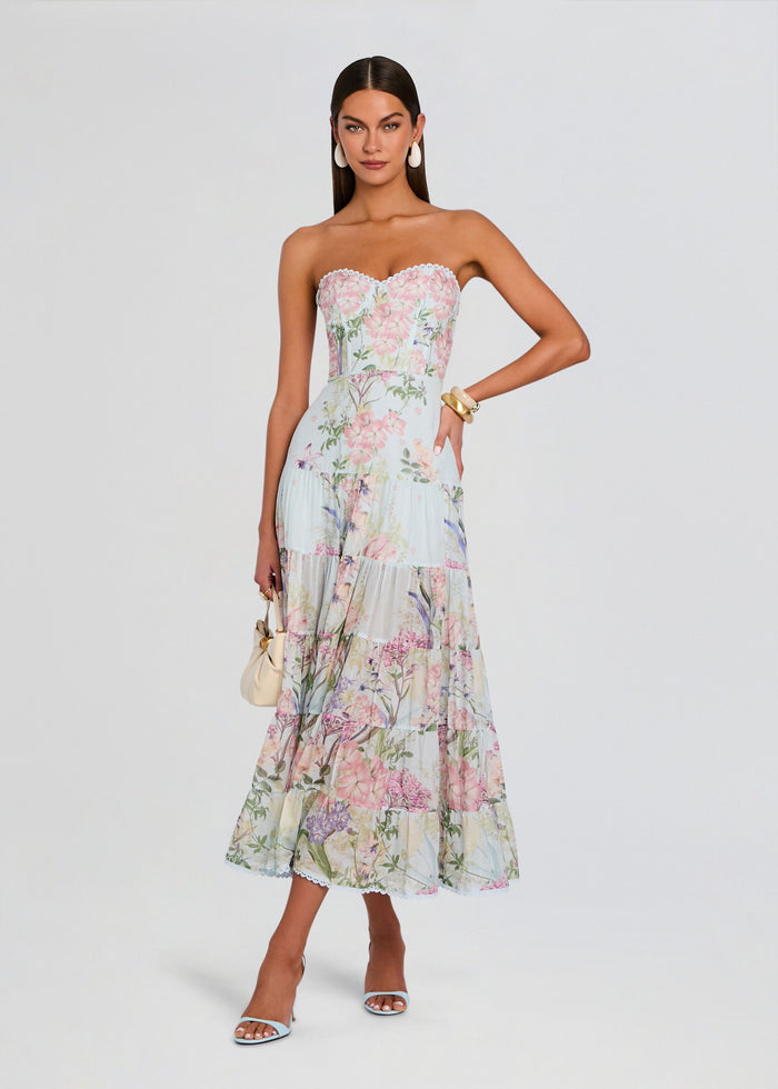 Full-length view of a model in a pastel floral strapless long dress with a lace-trimmed bodice and tiered skirt. media 1 of 5
