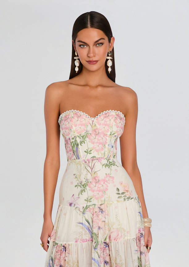 Model wearing a strapless pastel floral long dress with lace trim at the bust and a tiered skirt.