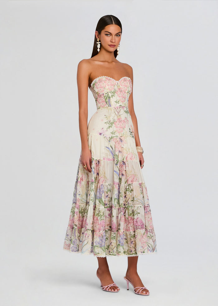 Full-length view of a model wearing a strapless pastel floral long dress with a tiered skirt and lace hem media 3 of 5