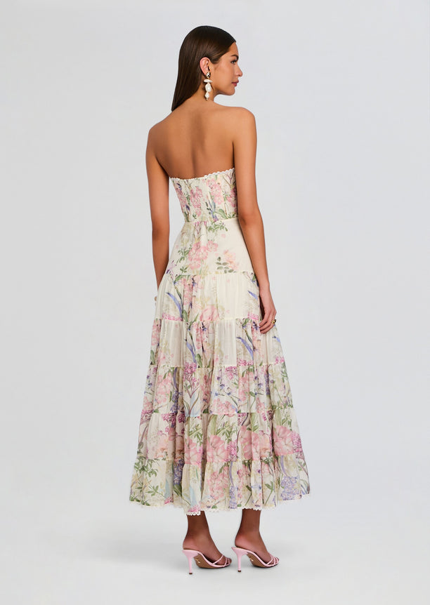 Back view of a strapless floral long dress with a smocked bodice and tiered skirt