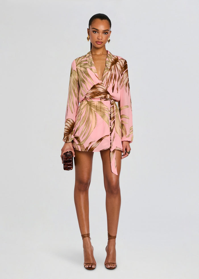 Model in a pink Fawn Mini Dress with Detachable Belt featuring brown palm leaf print wrap silhouette and long sleeves media 1 of 5