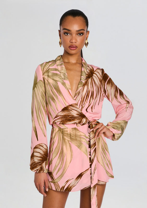 Model wearing pink palm leaf print mini dress with a detachable belt tied at the waist