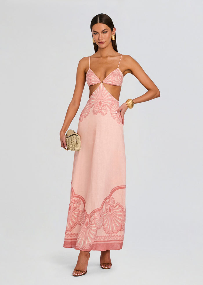 Maya Maxi Dress in blush pink with a waist cutout and central ring, thin shoulder straps, and a bold pink pattern along the hem media 1 of 5