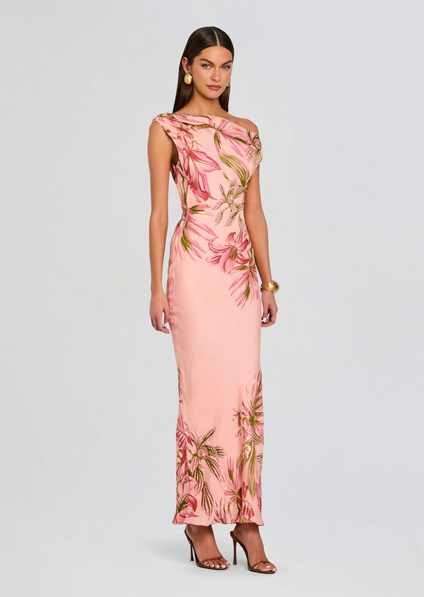 Pink tropical print one shoulder maxi dress on a model with gold earrings and bracelet