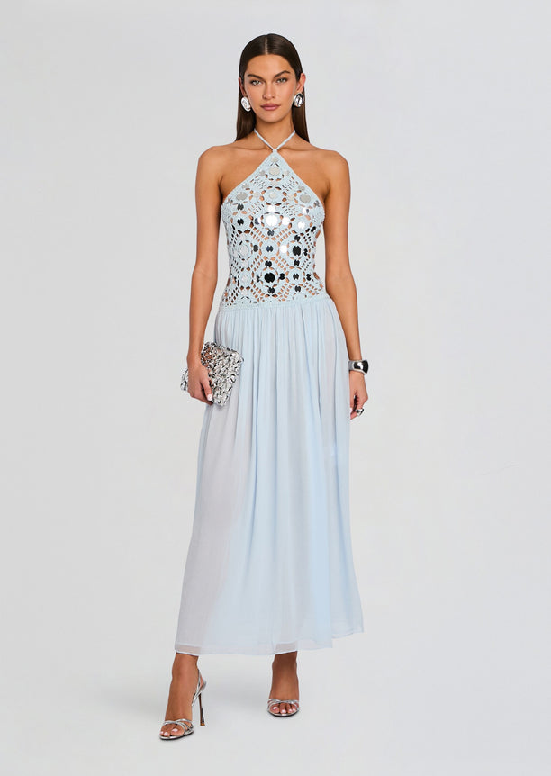Model in a pale blue crochet halter dress with a lace bodice and flowing skirt.