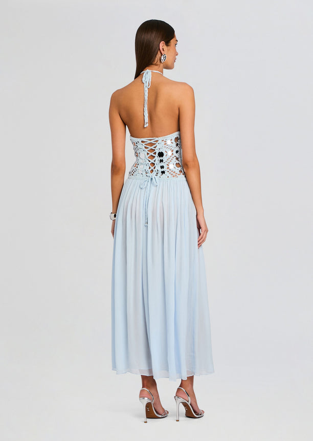 Back view of light blue crochet dress showing a lace up bodice and halter tie with a flowing skirt