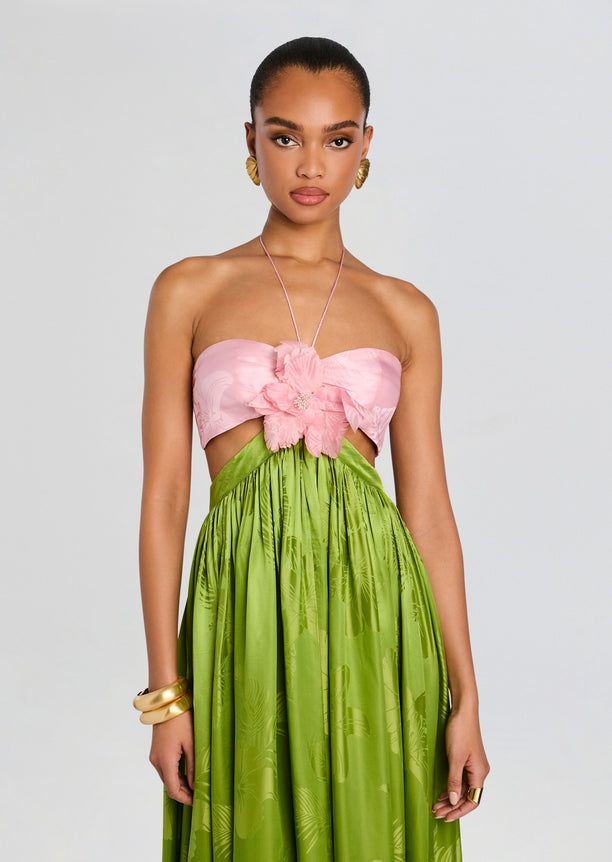 Model wearing Prudy Dress with a pink bandeau top and a large pink flower centerpiece, paired with a bright green tropical skirt.