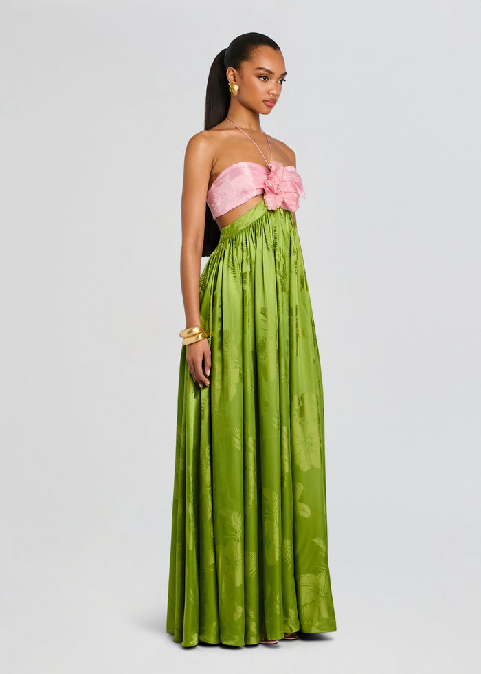 Full-length view of a model wearing the Prudy Dress with a pink bustier top, large flower detail, and a lime green maxi skirt. media 3 of 5