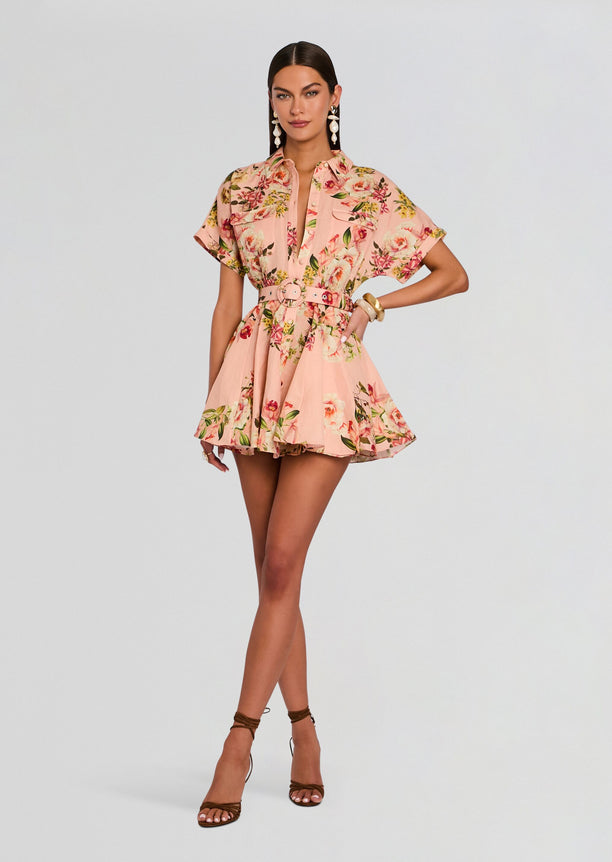 Model wearing a pink floral Ayla short dress with a matching belt buckle and sandals