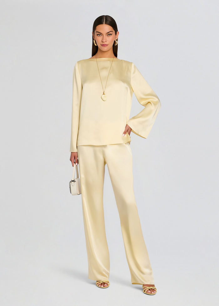 Model wearing a cream satin Blaine blouse with matching wide-leg pants and gold jewelry. media 2 of 5