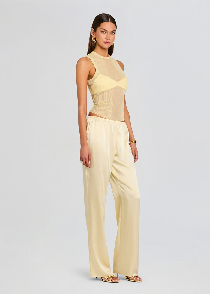 Full-length side view of Lillian Satin Pant in pale yellow satin with a cream sleeveless top. media 4 of 5