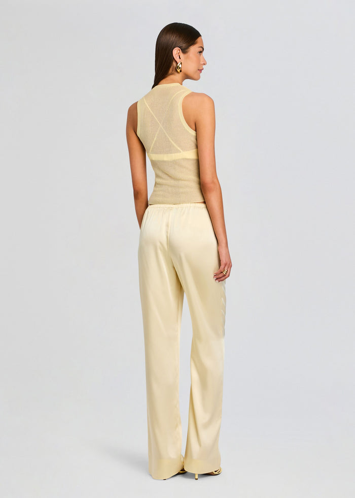 Back view of a model wearing cream satin wide-leg pants with a beige knit top. media 5 of 5