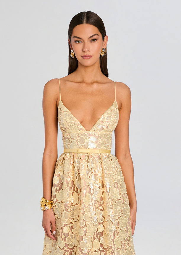 Front view of a champagne sequin lace midi dress with a plunging neckline and thin spaghetti straps belted at the waist