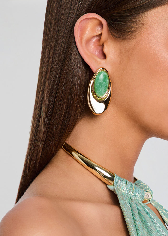 Side view of a model wearing a gold-tone Blare earring with a green oval stone media 2 of 5