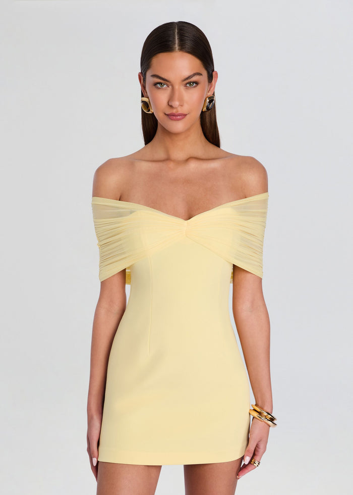 Portrait of a model wearing the pale yellow off-shoulder Jayne Mini Dress with a ruched sweetheart bodice media 5 of 5