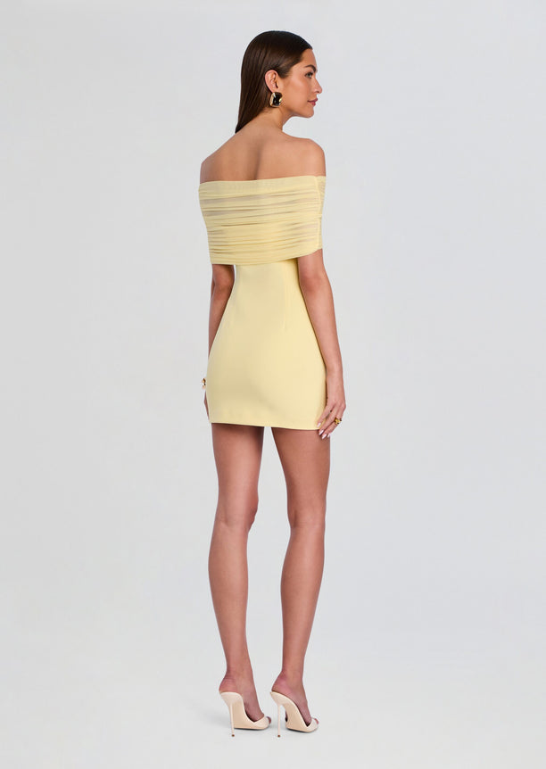 Back view of the pale yellow Jayne Mini Dress with an off-shoulder neckline and ruched wrap across the bodice