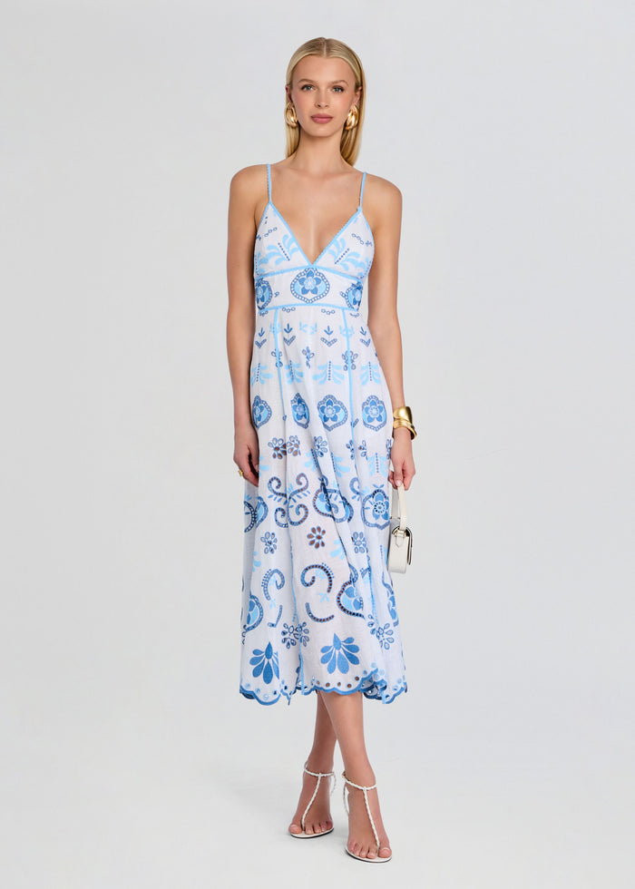 Front view of a model in a long light blue embroidered Gardea Dress with thin straps and flowing skirt. media 1 of 5