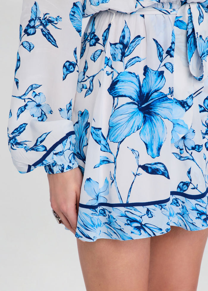 Close-up of Milo mini dress fabric showing blue floral print and gathered waist seam. media 2 of 5
