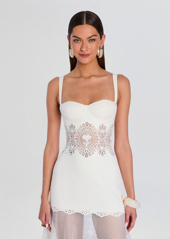 Front view of Olenna Dress a white bustier top with a wide lace waist panel and sheer lace midi skirt. media 5 of 5