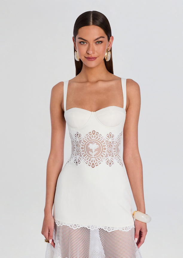 Front view of Olenna Dress a white bustier top with a wide lace waist panel and sheer lace midi skirt.