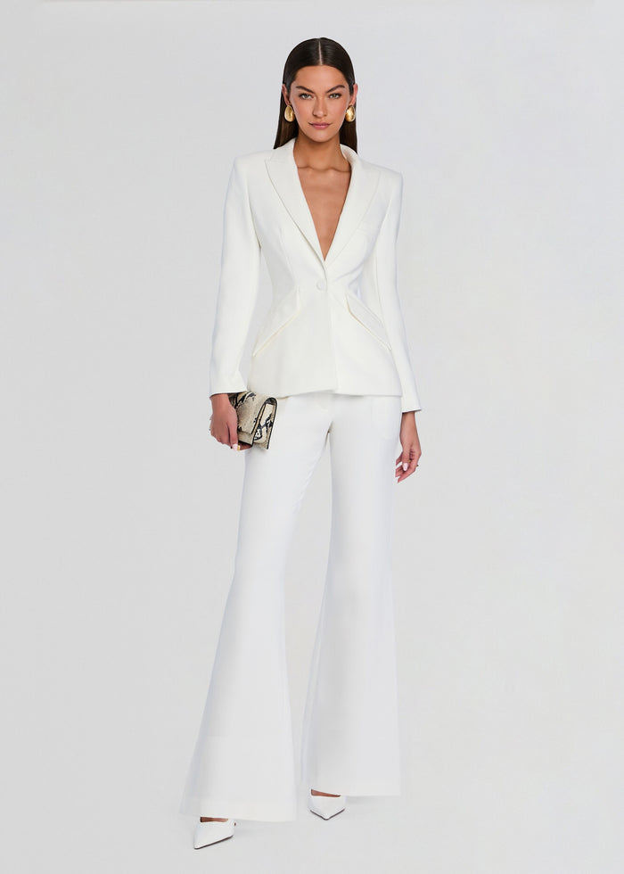 Model wearing a white tailored blazer with matching palazzo pants and a snake print clutch. media 2 of 5