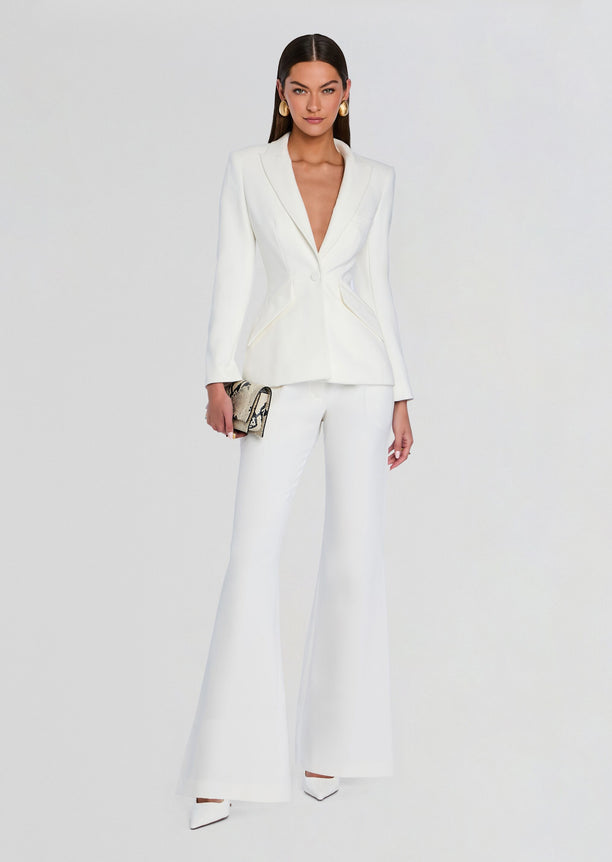 Model wearing a white tailored blazer with matching palazzo pants and a snake print clutch.