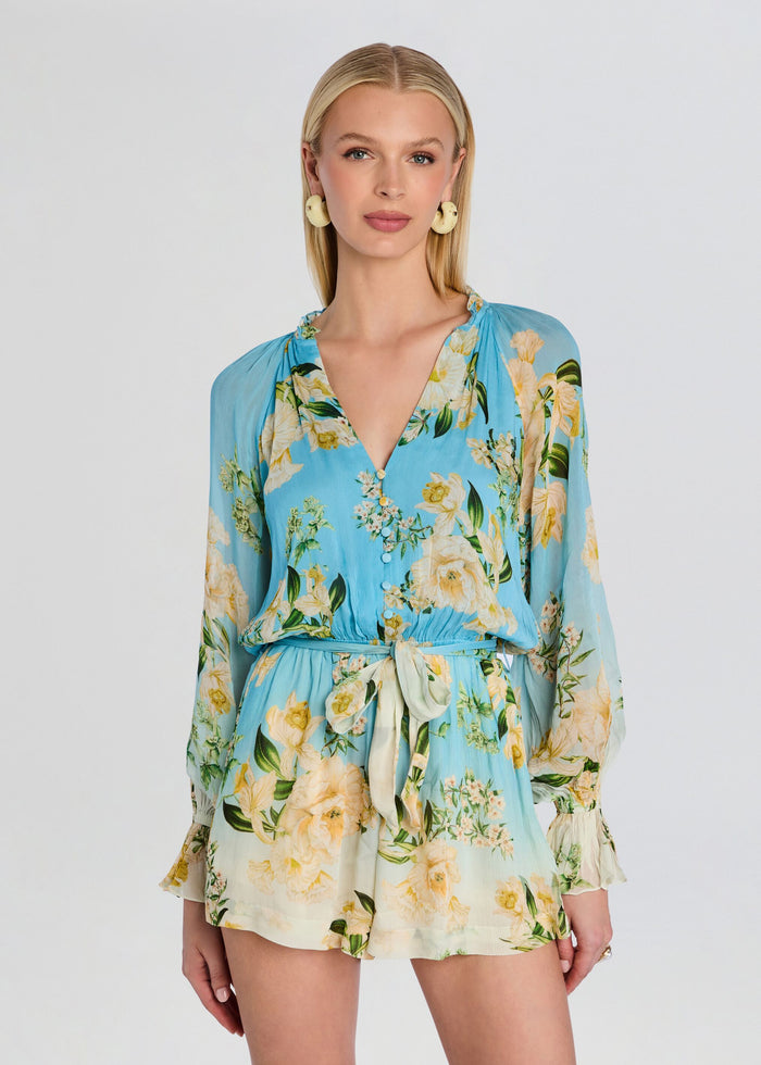 Model wearing a blue floral Ajia romper with a waist tie belt media 5 of 5