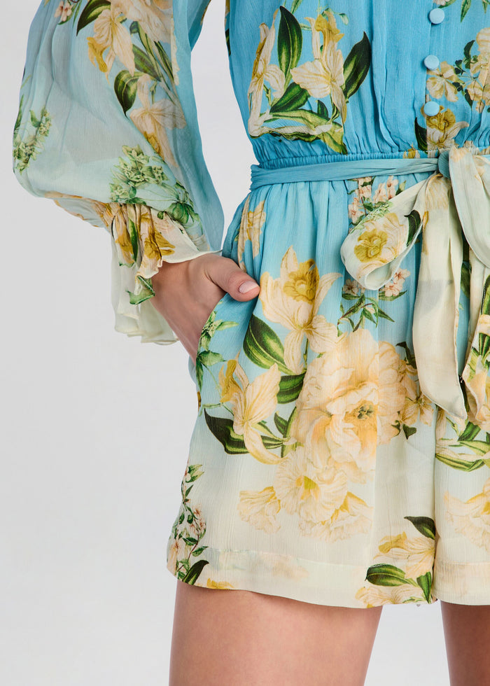 Close up of a blue floral Ajia romper showing the tied waist belt detail. media 2 of 5