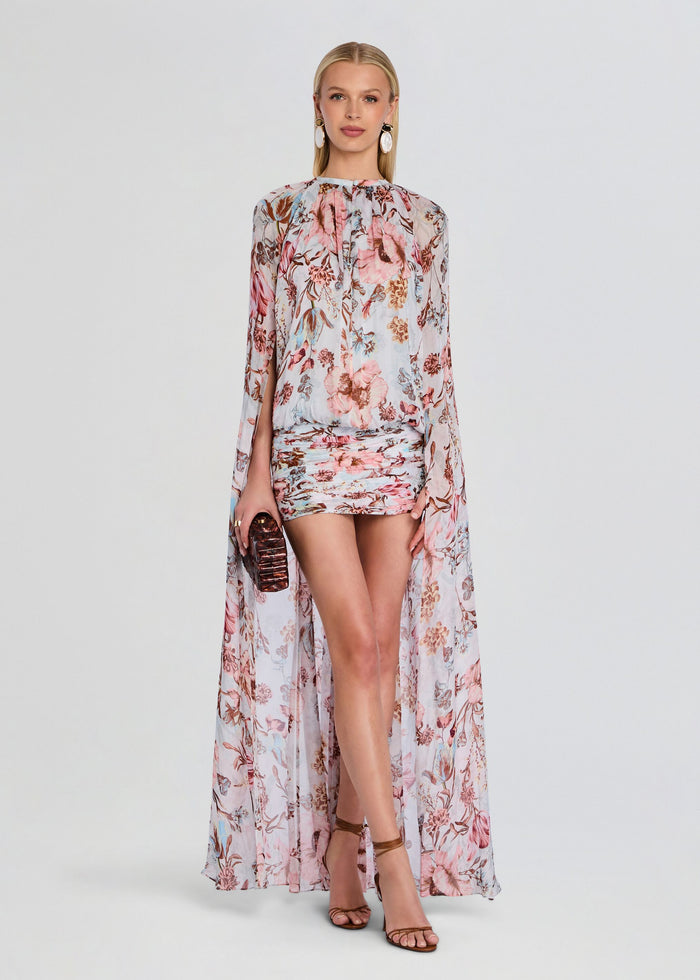 Ezra Ruched Cape Mini Dress in pale blue with pink floral print and cape overlay on a model media 1 of 5