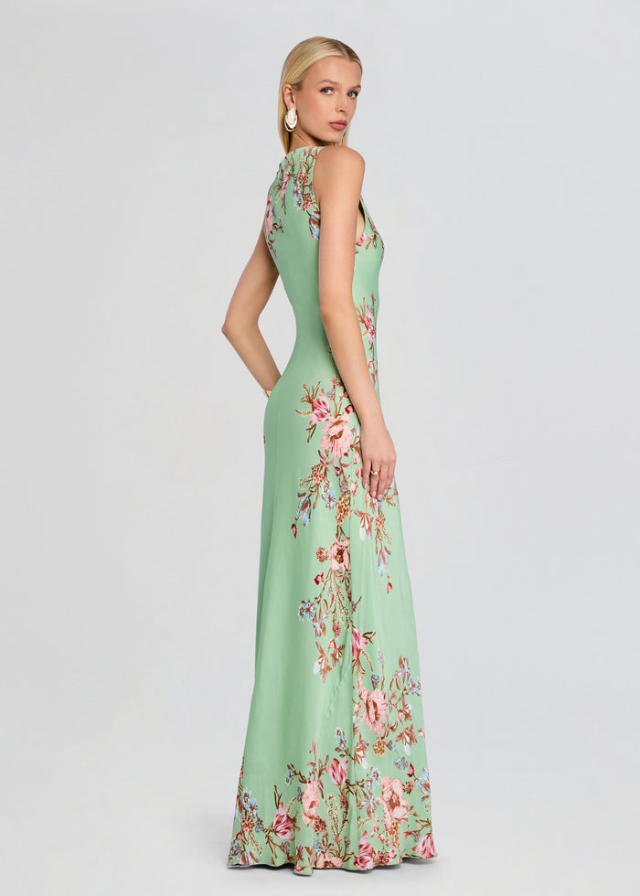 Side profile of a model in a green floral Ezra Bias Maxi Dress with a fitted bodice and flowing skirt media 4 of 6