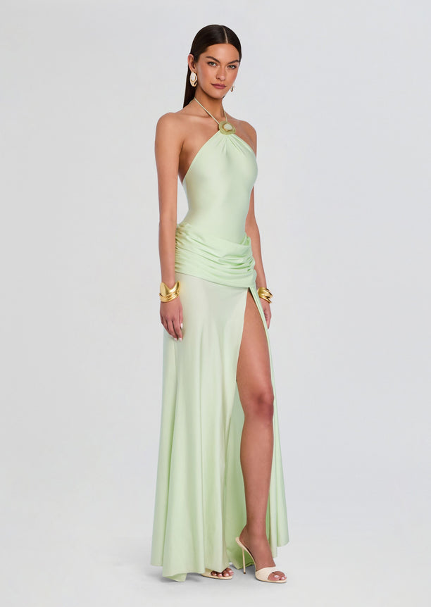 Valentine Maxi Dress in mint green halter neck with ruched waist and high slit, worn with gold jewelry.