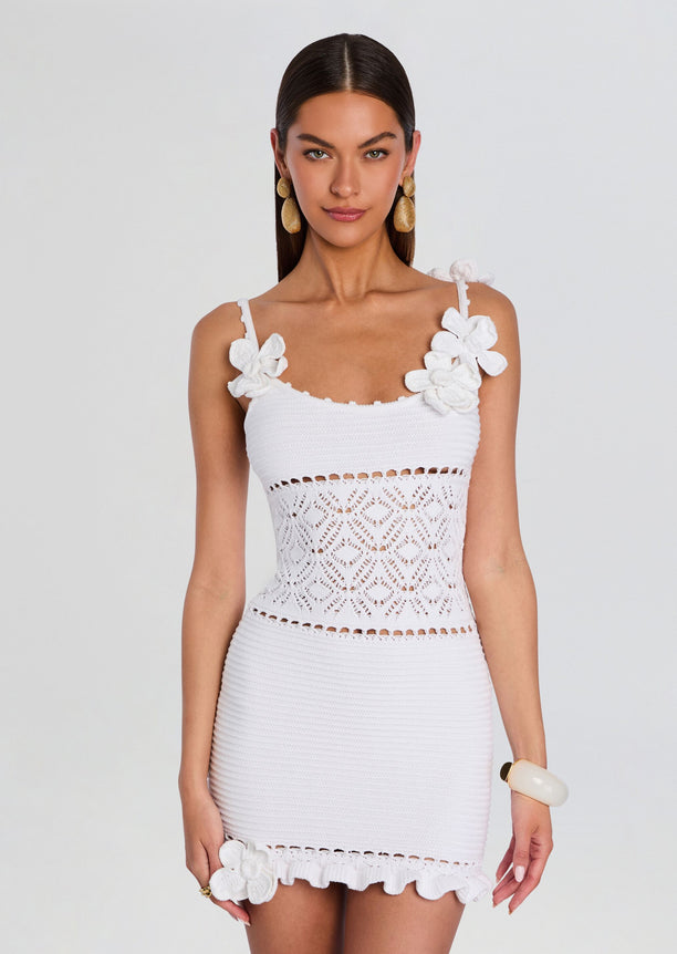 Front view of a white crochet dress with floral shoulder straps lace waist panel and a frilled hem.