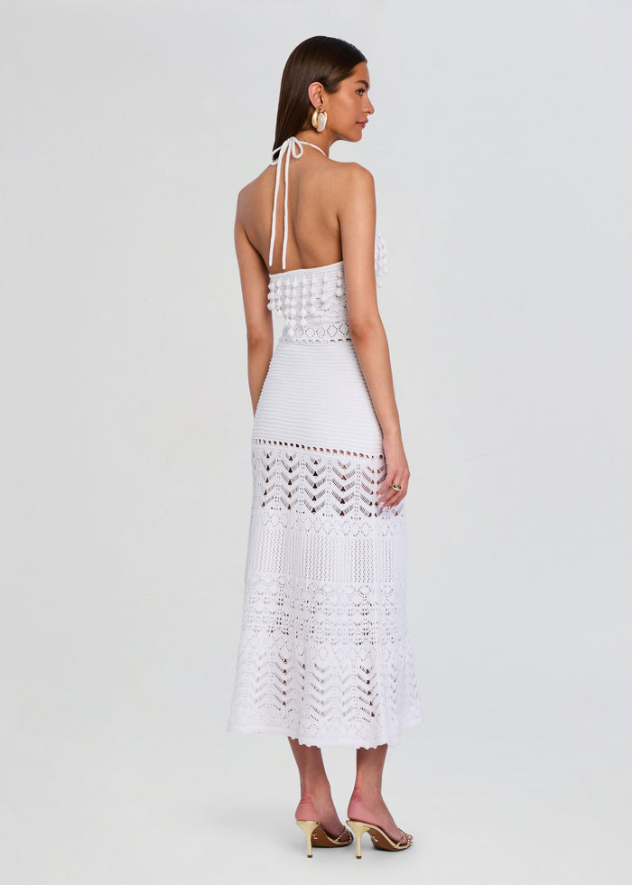 Back view of a model in a white crochet dress tied at the neck open back and tiered lace skirt media 4 of 5