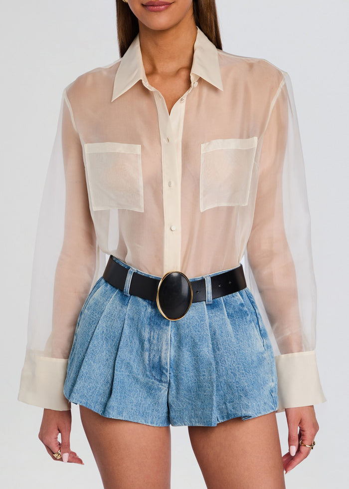 Model wearing the Pertie Belt with an oval black stone set in a gold-tone bezel over a sheer white blouse and denim shorts media 3 of 3