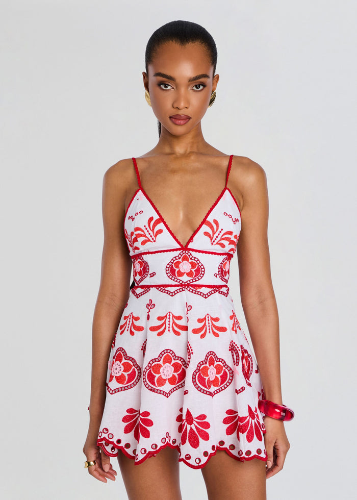 Front view of the Jela Short Dress with red embroidered pattern on white fabric and a flared mini hem. media 5 of 5
