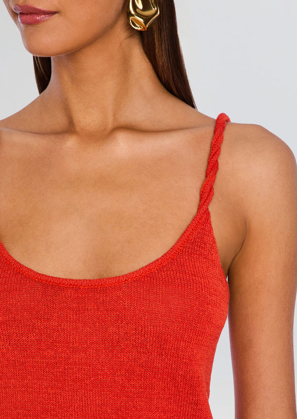 Close up of the red knit fabric highlighting the braided shoulder strap and scoop neckline.