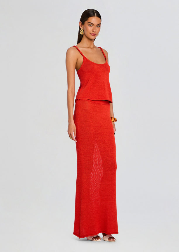 Model in a red knit tank top with braided straps paired with a matching red knit maxi skirt.