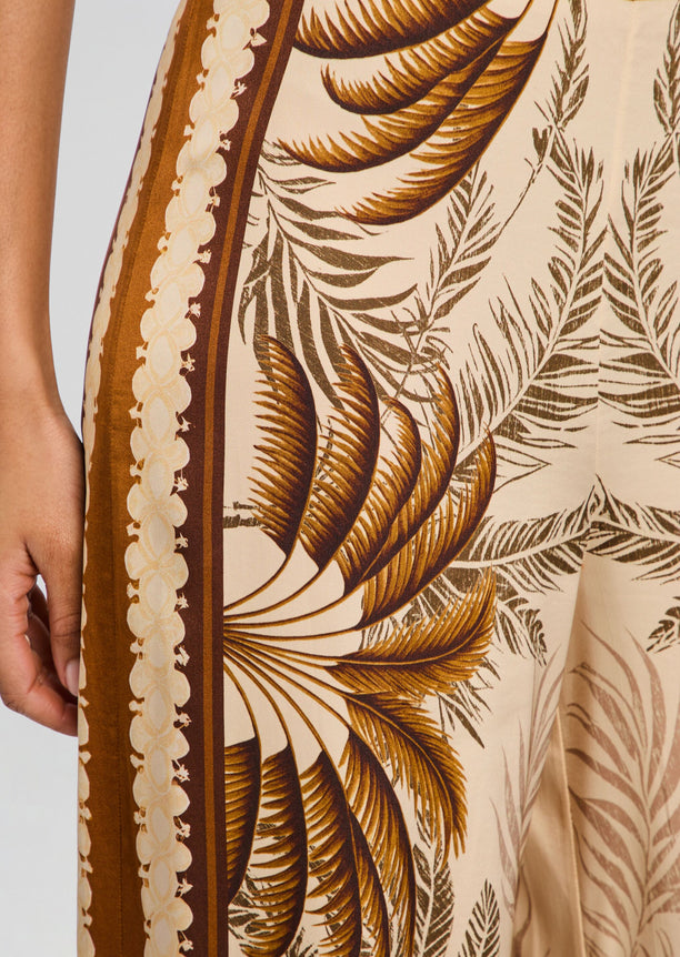 Close-up of the tropical palm print on Sunny Pant fabric with brown border on cream background.